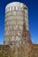 Old concrete steve silo partially covered with autumn colored vines