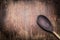 Old cooking spoon on aged wooden background, top view.