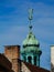 Old copper plated tower detail with clock under blue sky