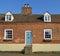 Old Cottage with steps to a very high front door.