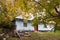 Old country house with walnut tree in desolate yard, cloudy autumn day, green ecological tourism