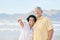 Old couple at beach, hug and travel with smile, retirement and love outdoor, vacation with view and relax in nature
