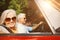 Old couple in a car smiling at camera