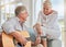 Old couple, guitar and love in home, sofa or couch playing a romantic, lovely or affection musical song for wife