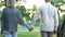 Old couple holding hands and walking in park, romantic date, love and trust