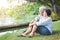 The old couple hugged each other with love and happiness in the garden with a large pond.