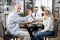 Old couple sitting with doctor at desk and giving high five