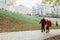 Old couple is walking in the green park. Fifty years together love story. Grandma and grandpa kissing. Grandmother and grandfather