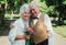 Old couple is walking in the green park. Grandmother and grandfather at their golden wedding anniversary celebration. Fifty years