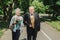 Old couple is walking in the green park. Grandmother and grandfather at their golden wedding anniversary celebration. Fifty years