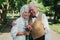 Old couple is walking in the green park. Grandmother and grandfather at their golden wedding anniversary celebration. Fifty years