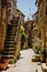 Old courtyard in Pitigliano with vases with flowers and with st