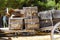 An old covered wagon wheel. Traditional wooden tumbrel, wooden crates loaded