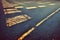 Old cracked textured asphalt road with traffic marking rough abstract background. Aged grainy urban roadway with stripe