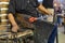 Old craftsman cutting and blowing the glass in fusing temperature to make a bottle with the old technique of blown glass.