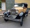 Old cream 1930s Ford Model A double phaeton convertible parked in the street. Classic car show.