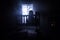 Old creepy eerie baby crib near window in dark room. Scary baby silhouette in dark. A realistic dollhouse living room with