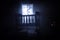 Old creepy eerie baby crib near window in dark room. Scary baby silhouette in dark. A realistic dollhouse living room with