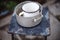 Old crockery on a retro stool. Aluminum pan and enameled mug on a chair