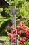 Old cross and red flowers in Holloko village, Hungary