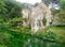 Old crumbling house on a small river in the garden of Nymph in Italy.