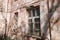 An old, crumbling window with a rusty bars on it. Damaged building