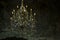 Old crystal chandelier with candles in a dark dungeon. Old brick walls.