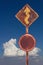 Old curved traffic sign with sky clouds.