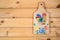old cutting board with wood burning and colored drawing a rooster hangs on a nail on the wooden plank wall. children`s diy craft.