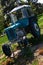 Old Czechoslovak agricultural tractor painted light blue and white, placed as decorative element in park between flower beds