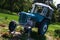 Old Czechoslovak agricultural tractor painted light blue and white, placed as decorative element in park between flower beds