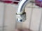 An old damaged faucet with rust scratches and peeling chrome. Concept of problems with home equipment