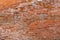 Old and damaged orange brown brick wall