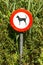 Old damaged sign in the bushes - dogs forbidden