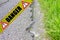 Old dangerous damaged cracked asphalt road surface with patch - concept image with danger text on it