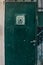 Old Dark green emerald metal dirt door with keyhole and rusty metal lockas a beautiful vintage background