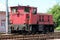 Old dark red electric locomotive parked on railway tracks waiting for departure from railway station