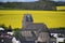 old dark stone church in Mayen-Alzheim in front of yellow oilseed fields