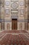 Old decorated stone wall, marble decorations and arabesque decorated wooden door, al Refai Mosque