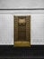 Old decorative brass metal door on a background of black and white wall with ceramic tiles. Decorative metal door on the track