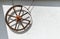 Old decorative wheel on a white wall, nostalgia style