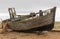 Old derelict boat on pebble beach.