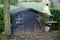 Old desolate barn with dirty vintage window, cute small house on back yard