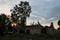 Old destroyed buildings among trees and green grasses. Abandoned buildings. Landscape