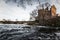 Old destroyed mill on a coast of stormy river. Toned