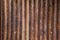 Old detailed aged vintage rusty corrugated red brown textured zinc metal sheet exterior fence used in construction industry