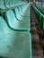 Old, deteriorated, empty green seats in a sports stadium