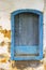 Old and deteriorated wooden window painted in blue