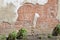 Old deteriorating clay brick wall texture showing faded and cracked paint