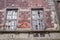 Old devastated wall of abandoned house with broken windows